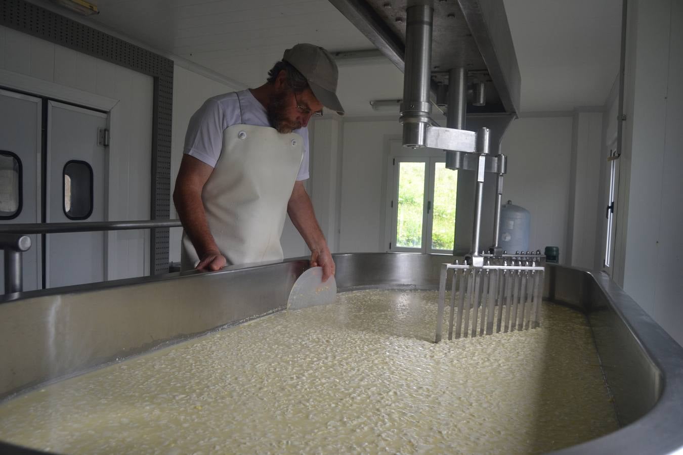 Javier Campo introduce manualmente la cuajada en los moldes para elaborar el queso.