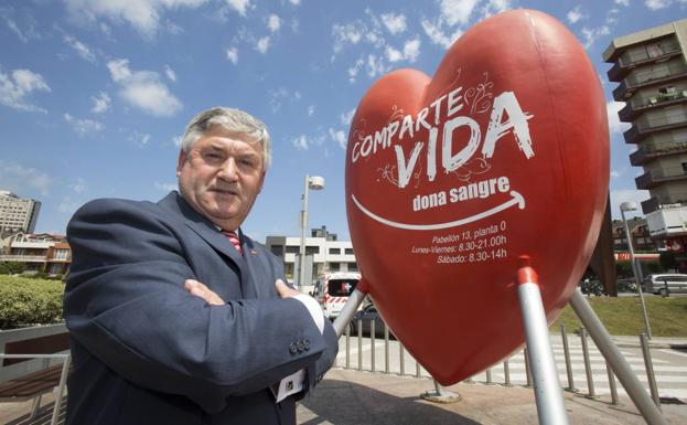 Francisco García posa junto al corazón de donaciones situado frente al Hospital de Valdecilla