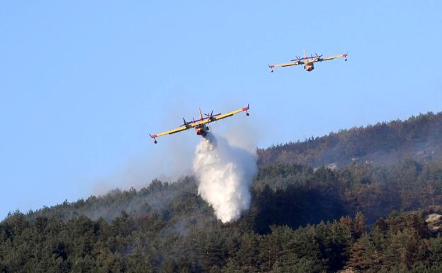 Los hidroaviones del Ejército del Aire atacan el fuego declarado en las inmediaciones de la Granja, en el Parque Nacional del Guadarrama.