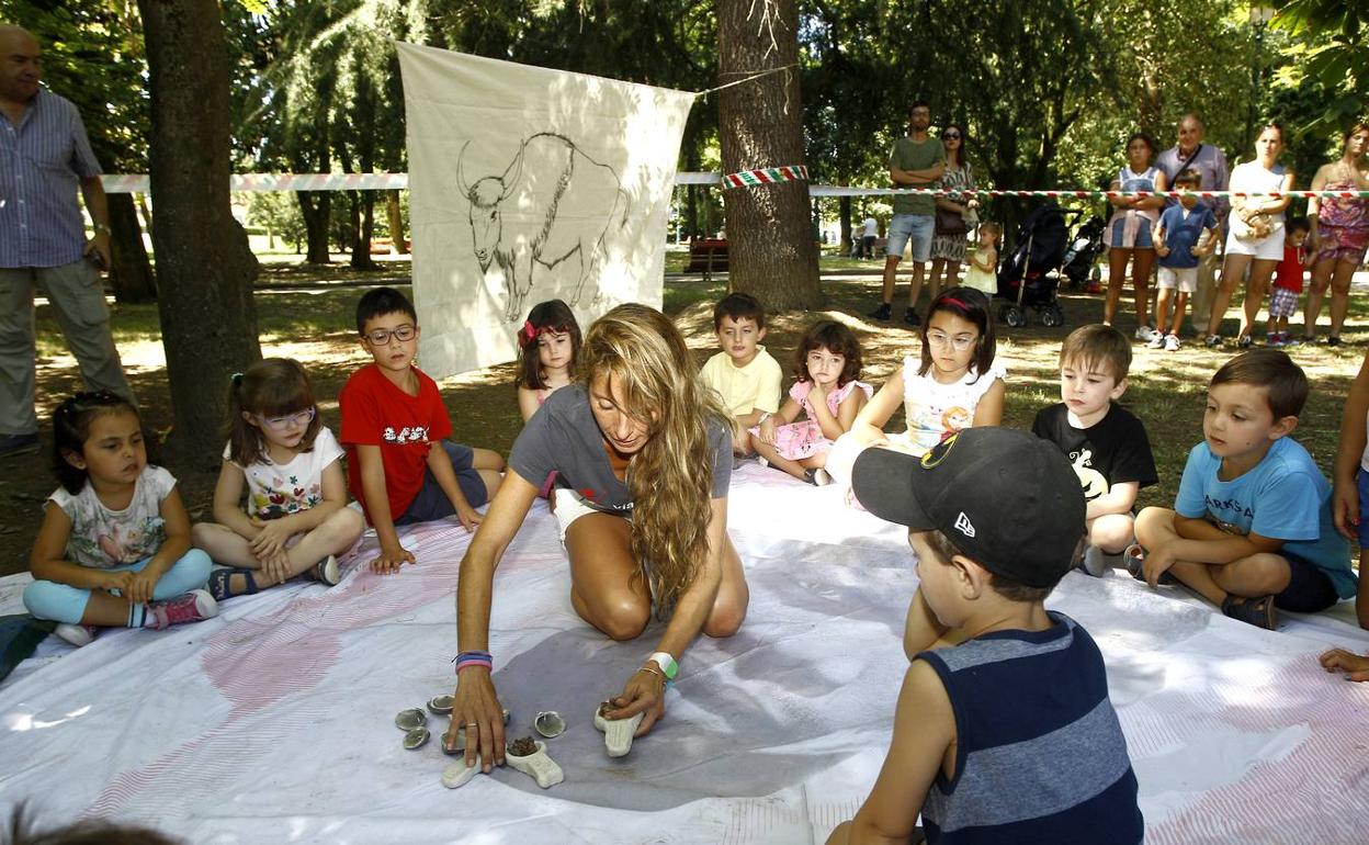 Alta participación. Una de las monitoras de los talleres explica a los pequeños qué van a hacer en el parque Manuel Barquín. 