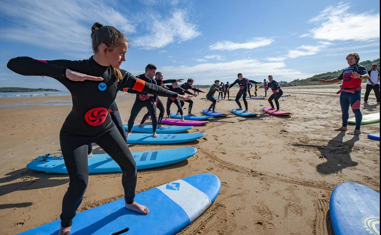 Alumnos de la Escuela Cántabra de Surf, en la playa de Somo, esta semana durante una clase de iniciación. 