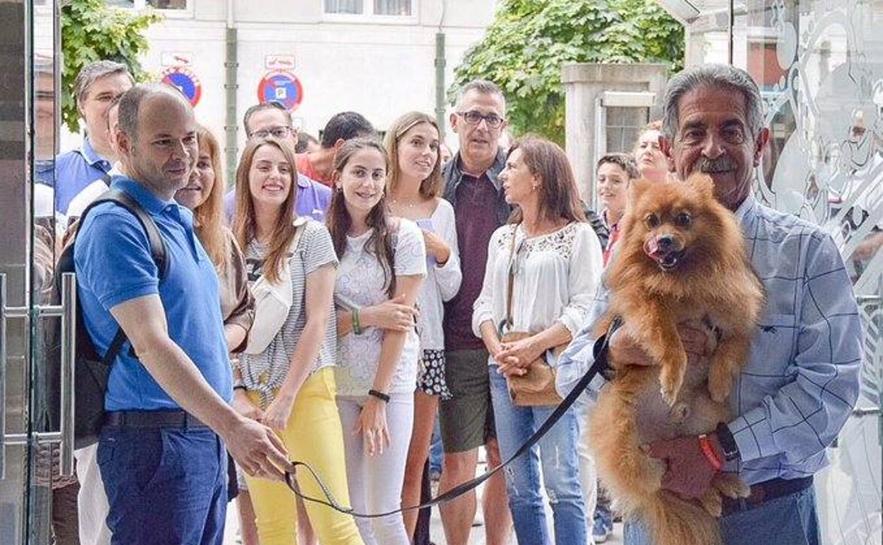 Revilla coge en brazos al perro de un grupo de Barcelona que acudió a saludarle a la sede del Gobierno.