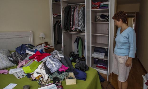 Una mujer observa las consecuencias de un robo en su vivienda. 