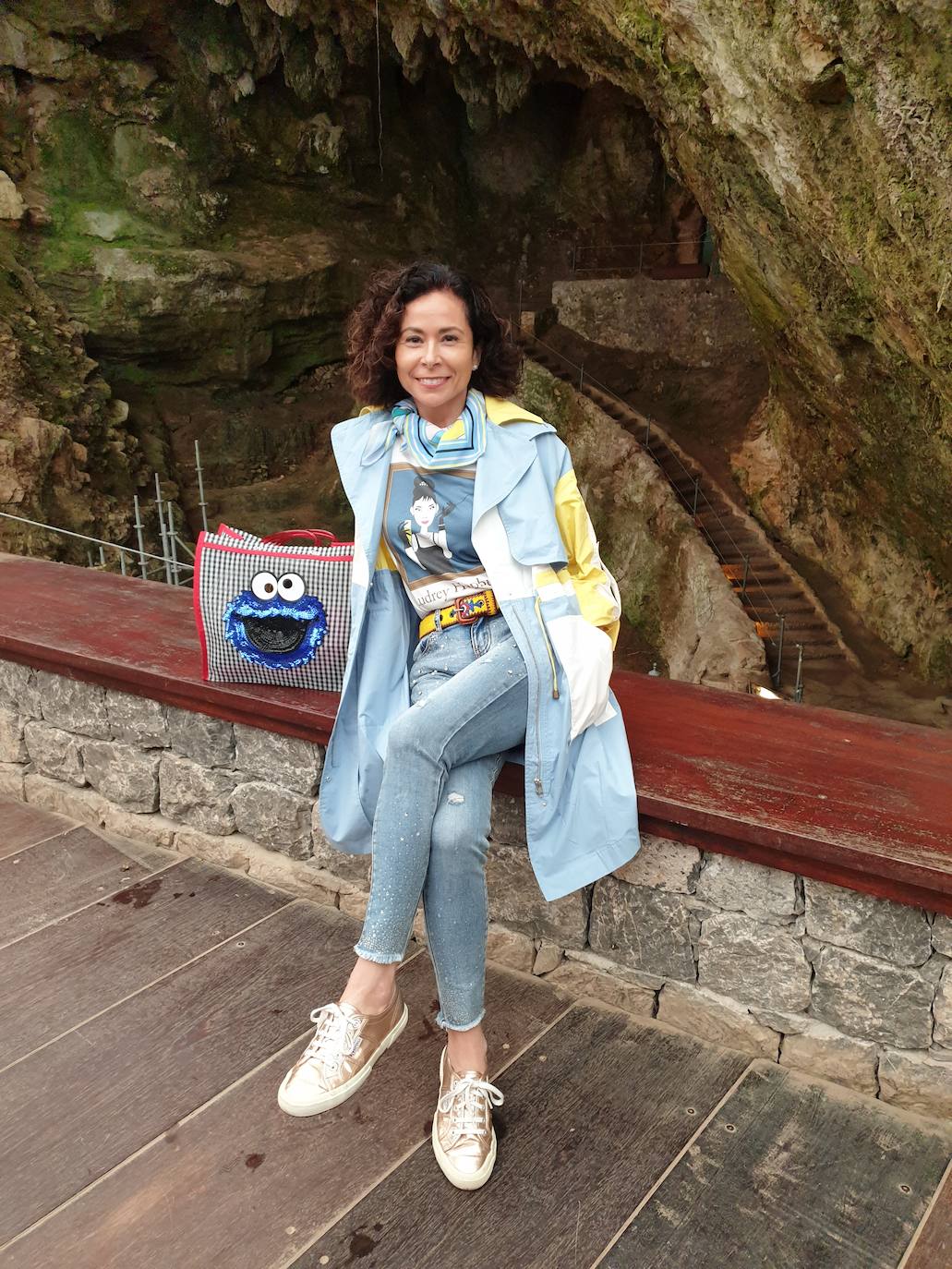 María Navedo (Madrid, pero natural de Cantabria, @mnavedos_) ha realizado un look en el que combina diferentes tonos de azules y distintos estampados. Camiseta con dibujo, jeans y gabardina de verano en azules con toques amarillos que vemos también en el cinturón y en el pañuelo que lleva en el cuello. Unas zapatillas en dorado completan su propuesta. Un look cómodo para sus excursiones veraniegas, acompañada por su bolsa mexicana.