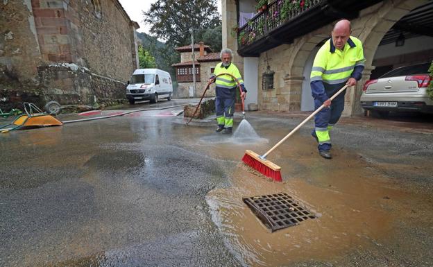 Dos operarios limpian las calles de Renedo de Cabuérniga.