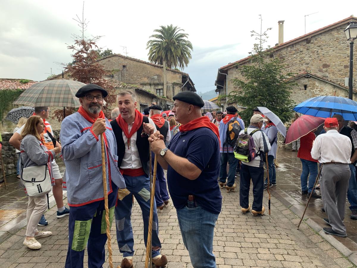 Los vecinos de Cartes tuvieron que sacar los paraguas para participar en el 'Día de las albarcas', caminando bajo la lluvia hasta Cohicillos