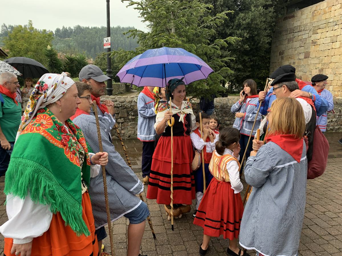 Los vecinos de Cartes tuvieron que sacar los paraguas para participar en el 'Día de las albarcas', caminando bajo la lluvia hasta Cohicillos