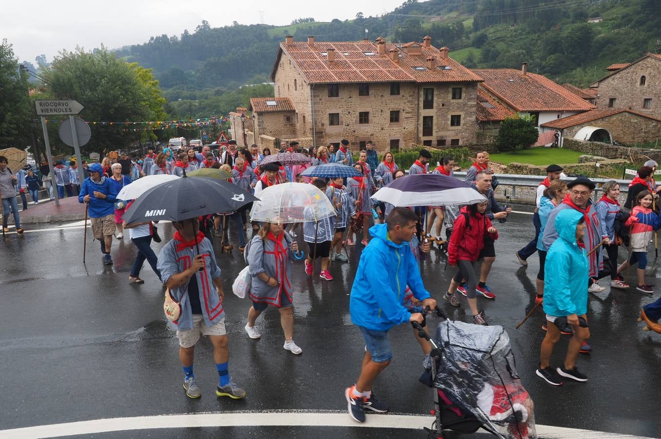 Los vecinos de Cartes tuvieron que sacar los paraguas para participar en el 'Día de las albarcas', caminando bajo la lluvia hasta Cohicillos