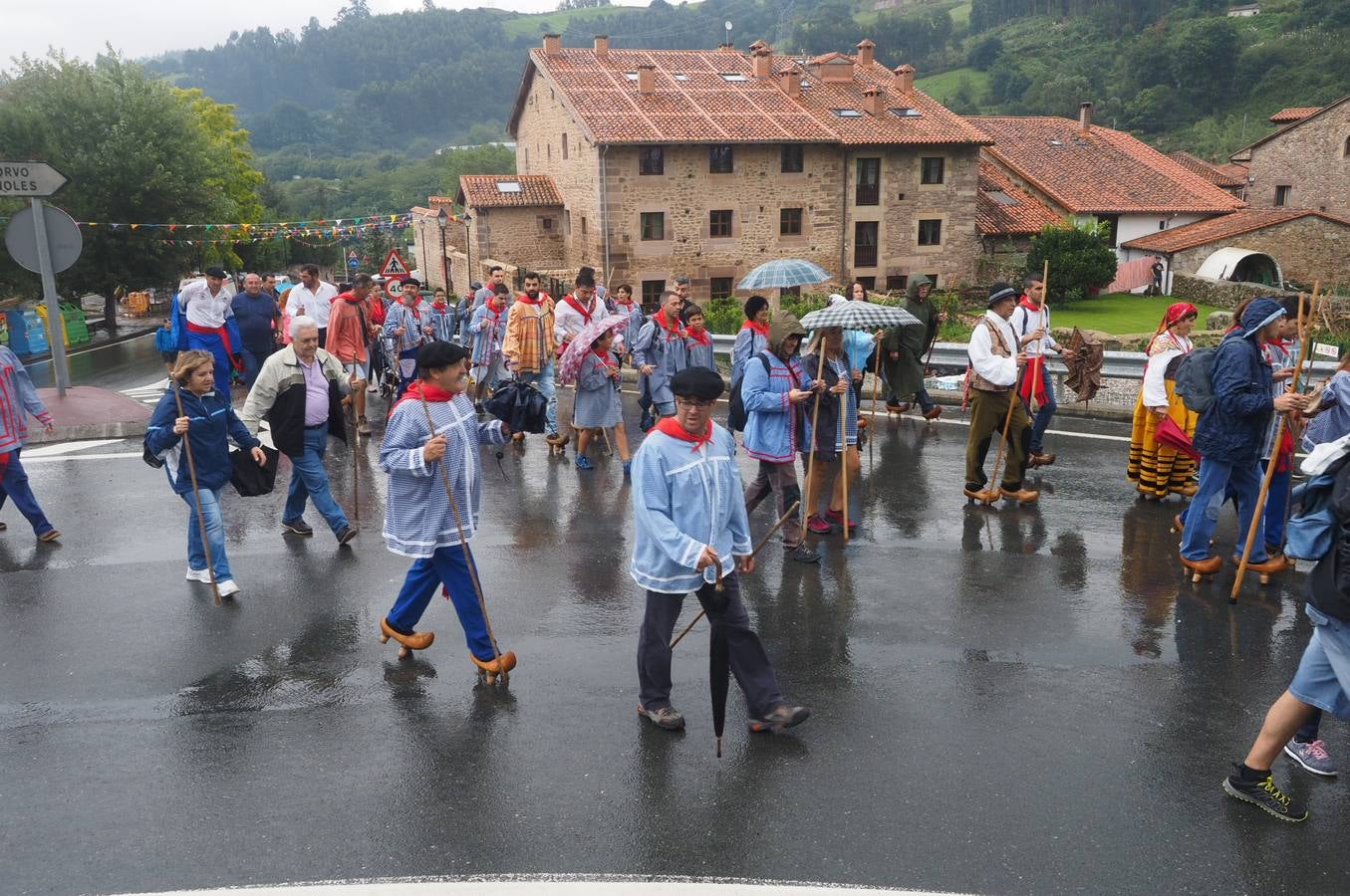 Los vecinos de Cartes tuvieron que sacar los paraguas para participar en el 'Día de las albarcas', caminando bajo la lluvia hasta Cohicillos