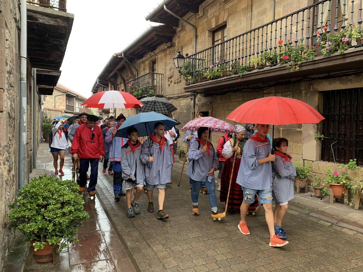 Los vecinos de Cartes tuvieron que sacar los paraguas para participar en el 'Día de las albarcas', caminando bajo la lluvia hasta Cohicillos