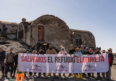 Imagen secundaria 1 - Los montañeros que participaron este domingo en la marcha han pintado el interior del refugio. En la última foto puede verse la placa que en verano pusieron ya en la puerta y en la que recuperaron el texto que había en 1935.