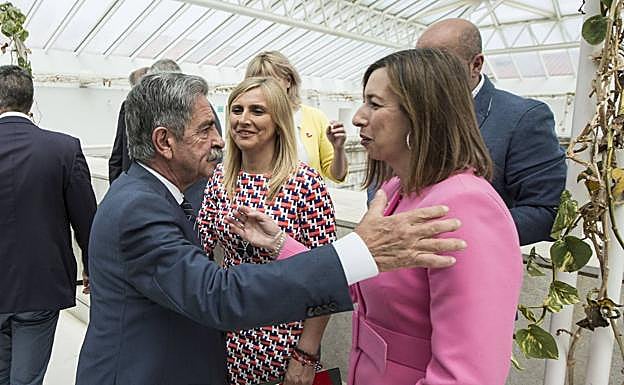 El presidente Revilla saluda a la consejera de Economía, María Sánchez, en presencia de Noelia Cobo, en el Parlamento. 