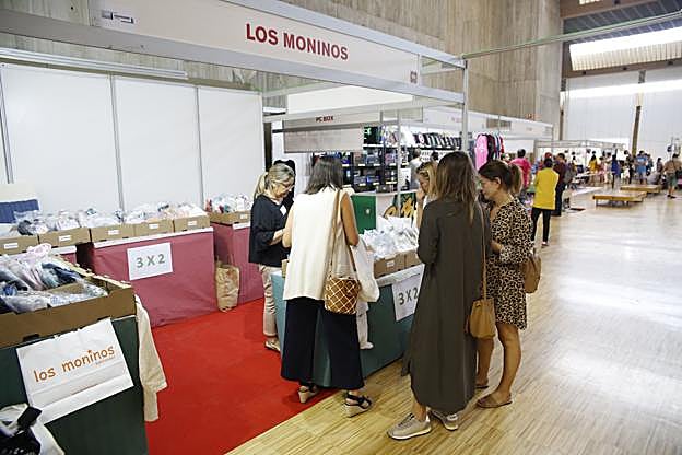  Clientes ojean un puesto en la feria, este viernes, en el Palacio de Exposiciones de Santander. :: Juanjo Santamaría