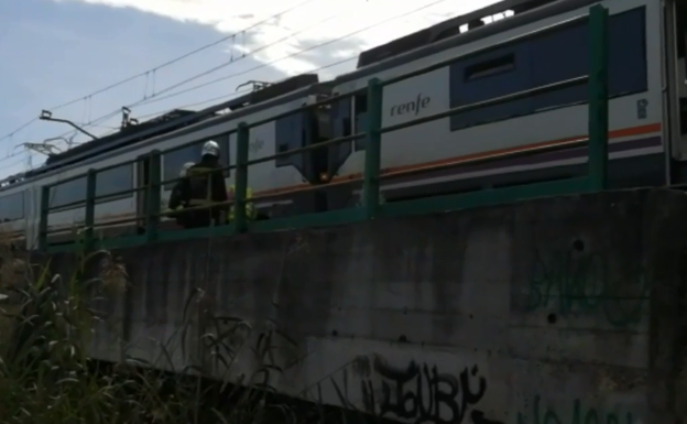 Los bomberos junto a un operario del tren revisan el vagón.