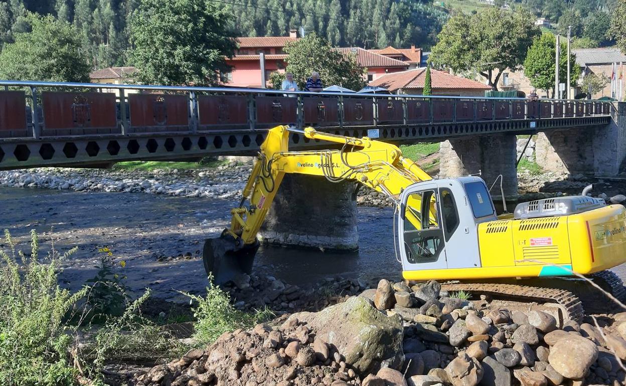 Una retroexcavadora limpia el río Besaya a su paso por Los Corrales.