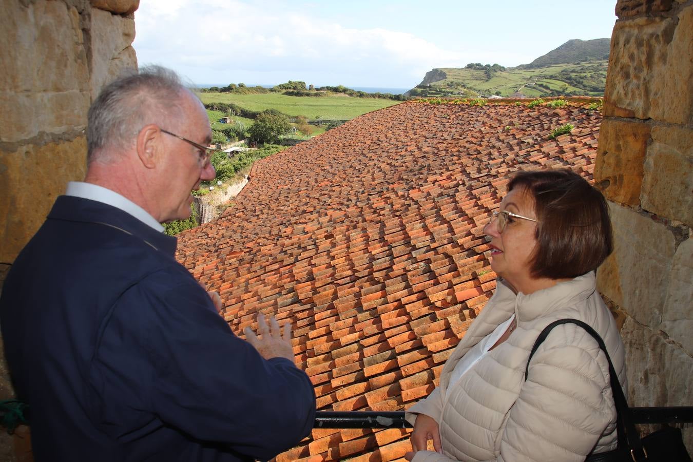 El párroco Juan Luis Cerro muestra el tejado del templo a la alcaldesa pejina.