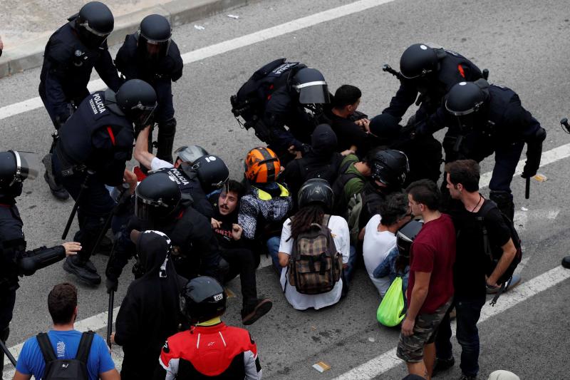 Miembros de los Mossos d'Esquadra cargan contra los centenares de personas que se agolpan ante el Aeropuerto del Prat 