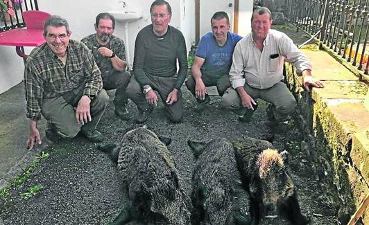 Cazadores de la cuadrilla 43, de Fernando González, con tres jabalíes cazados en el lote de Viaña. 