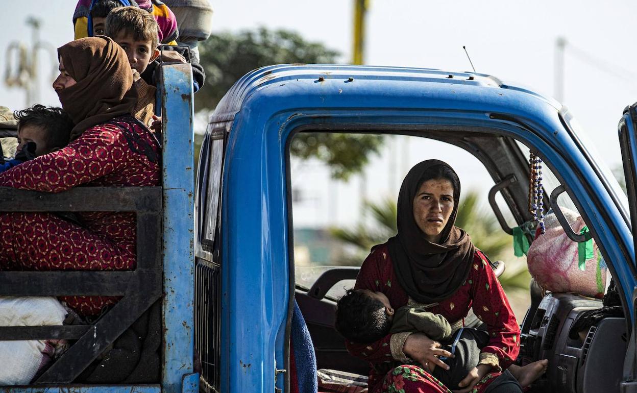 Familias sirias huyen de la zona de conflicto en la localidad de Ras al-Ain, en la frontera con Turquía.