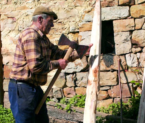 Lugareño relaizando labores de artesanía con madera.