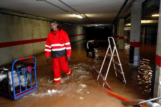 Los bomberos achican agua en uno de los garajes inundados del barrio La Pedreguera