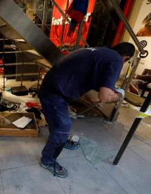 Imagen secundaria 2 - Arriba, una pintada en una calle de Barcelona. Abajo, operarios tratan de reparar los destrozos en una tienda. 