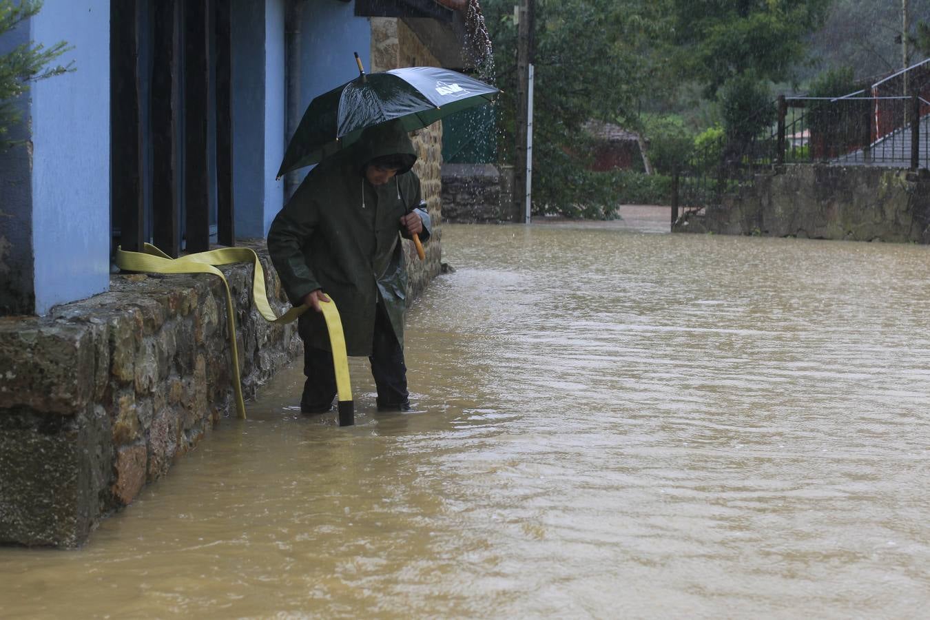 Vecino achicando agua en Treceño.