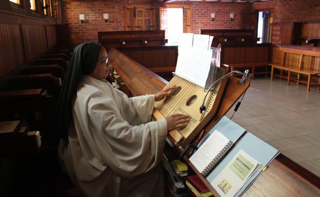 Sor Amparo interpretando una pieza en la cítara, dentro de la iglesia, el corazón del monasterio.