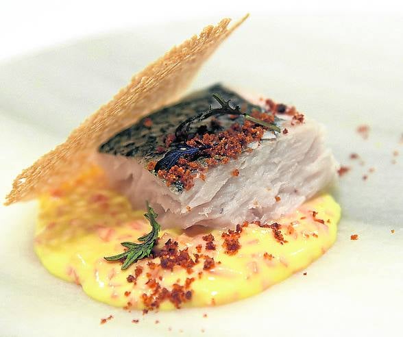 Merluza con falso risotto y curry. Para el risotto cortamos daditos de calabaza muy finos y, para la crema, leche, nata, queso mascarpone y pimienta. Después añadimos la calabaza cruda y retiramos del fuego. Colocamos el trozo de merluza en la plancha y la acabamos en el horno.