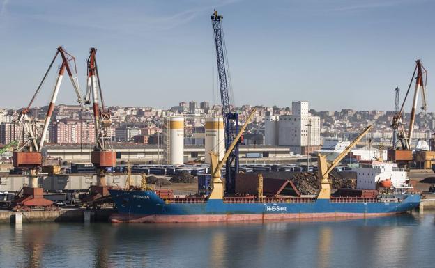 Un buque trabaja con chatarra en los muelles de Santander.