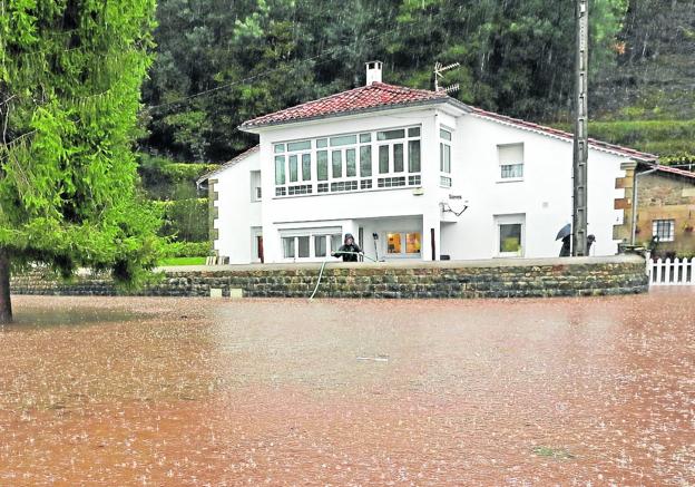 Un vecino de Villanueva achica agua en la finca de su casa en las últimas inundaciones.