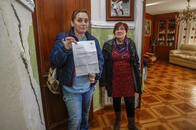 Lourdes Verdeja y Rosa Nieves Ibáñez muestran una de las grietas y la respuesta negativa del seguro. 