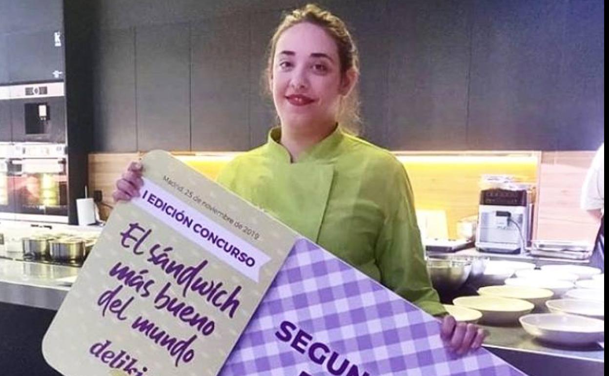 Lucía Fernández-Oruña con el cheque que le acredita como la autora del segundo mejor sandwich del concurso.