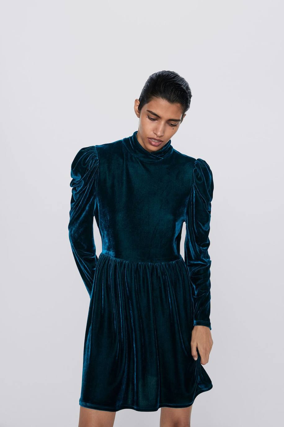 Vestido corto de Zara con cuello subido, manga larga y diseño de terciopelo en color verde, 29,95 euros.