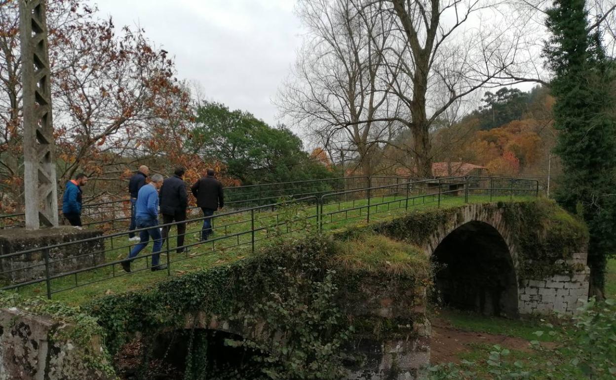 Los políticos atraviesan el antiguo puente de la campa de Santa Lucía, en Cabezón de la Sal. 