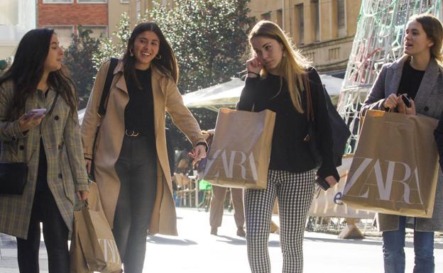 Cuatro jóvenes recorren el centro de Santander cargadas con las bolsas de sus compras. Las calles más comerciales de la ciudad se han llenado de gente y el ambiente ha sido distinto al de otros días.