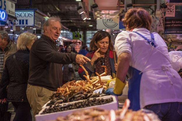 Una pareja escoge su compra con el consejo de la dependienta.