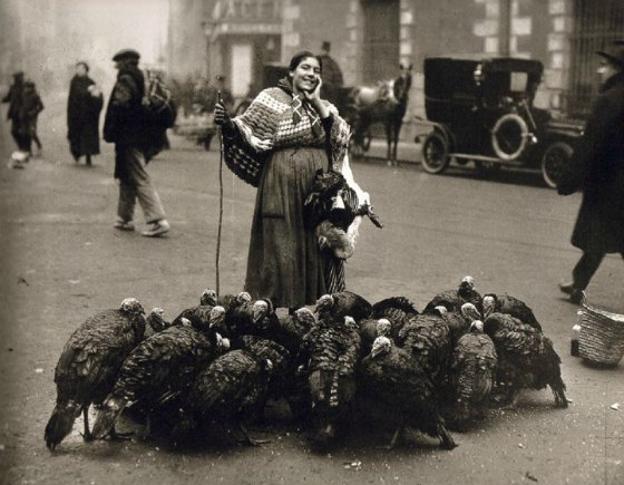 Mujer rodeada de pavos para su venta.