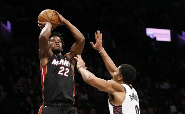 Jimmy Butler lanza a canasta ante la defensa de Spencer Dinwiddie. 