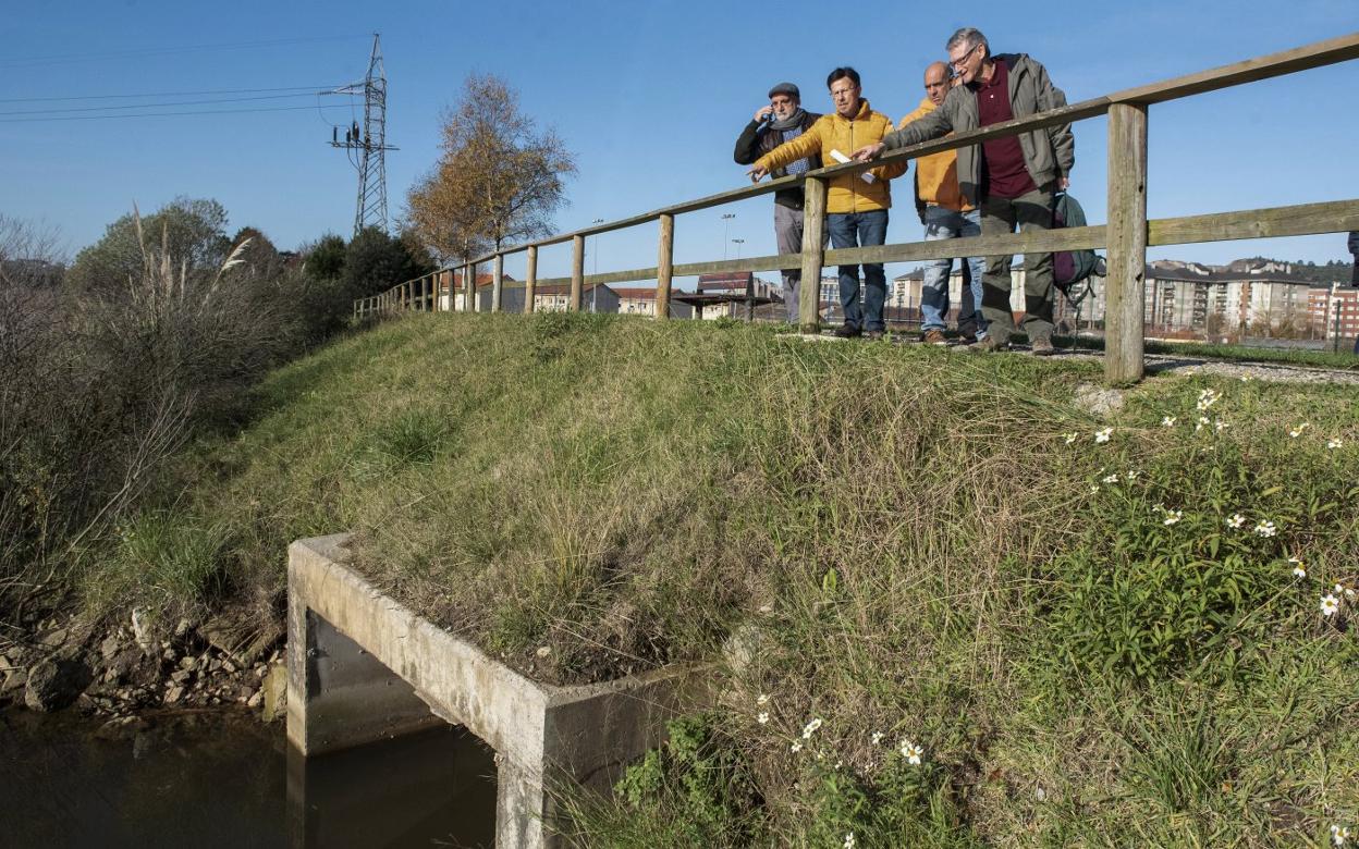 Los vecinos señalan el punto de la ría de Raos donde se producen los vertidos. 