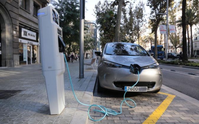 Un coche eléctrico cargándose en un puesto de la calle.