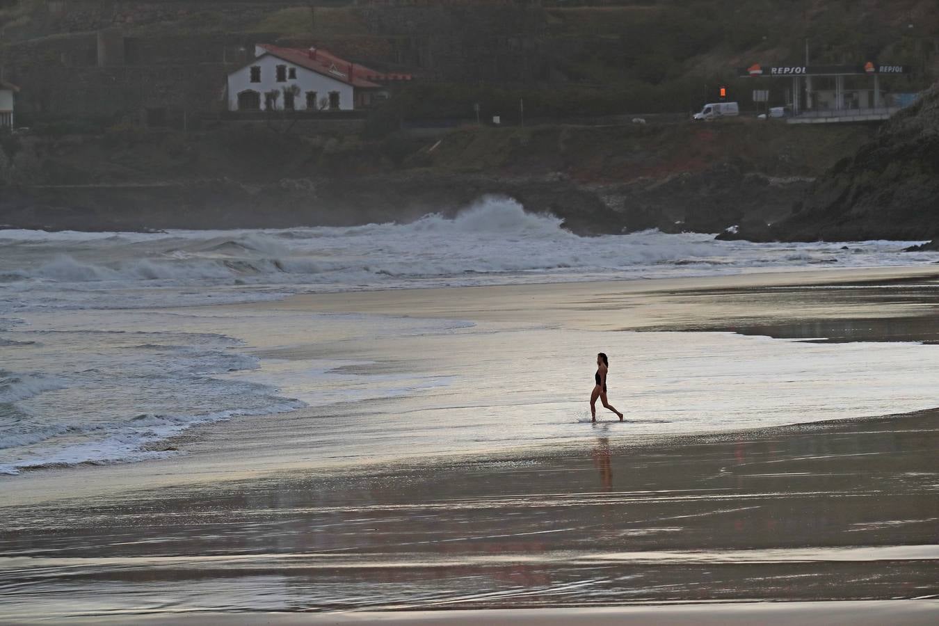 Una joven desafía el mal tiempo en la playa de Comillas.