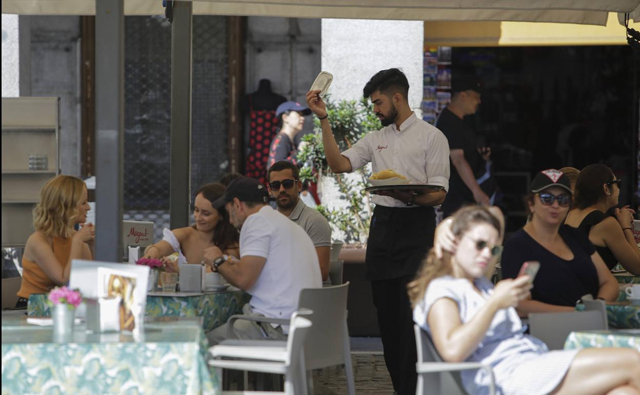 Un camarero atiende una terraza en Madrid.