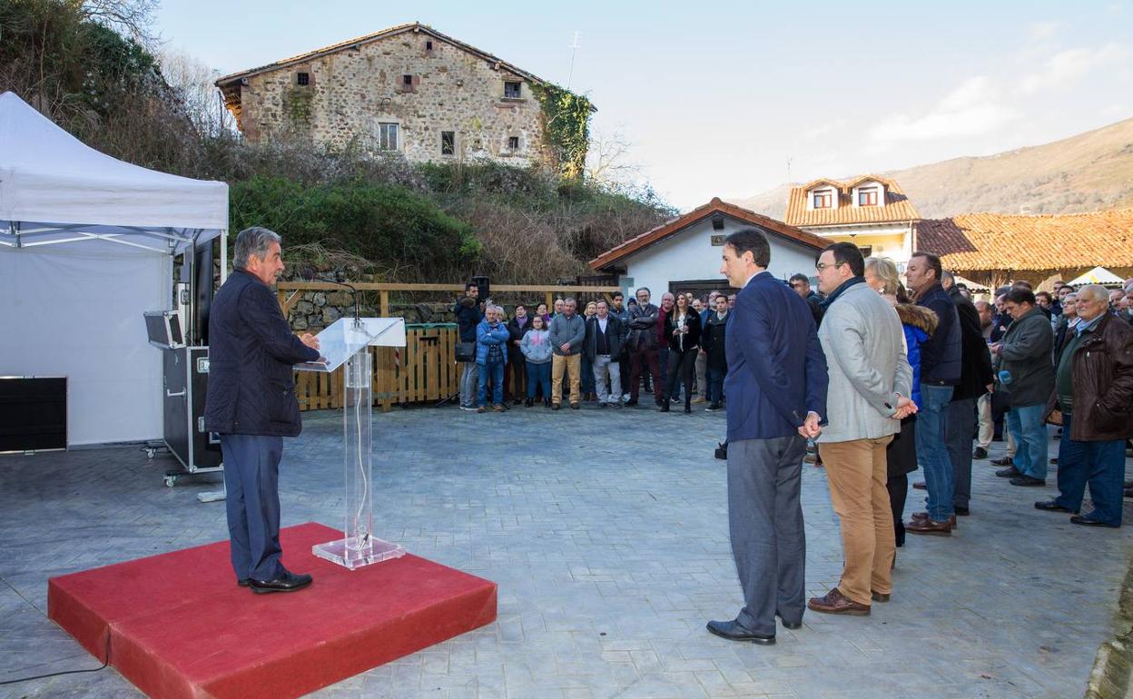 Revilla, subido en el estrado, habla a los vecinos de Ruente, observado por sus consejeros y las autoridades locales.