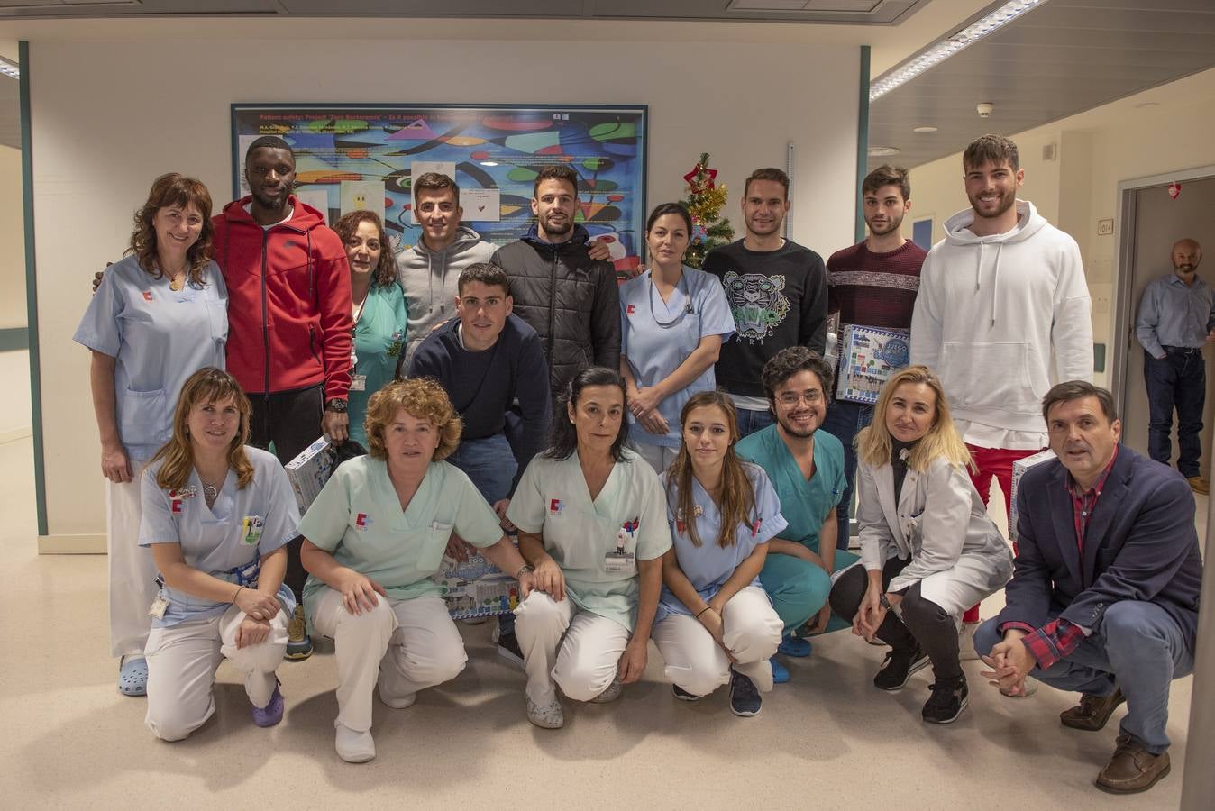 Trabajadores (médicos, enfermeras y auxiliares) de la planta 3 de Pediatría de Valdecilla y el director y la subdirectora de Valdecilla posaron con los jugadores del Racing que visitaron el hospital. 