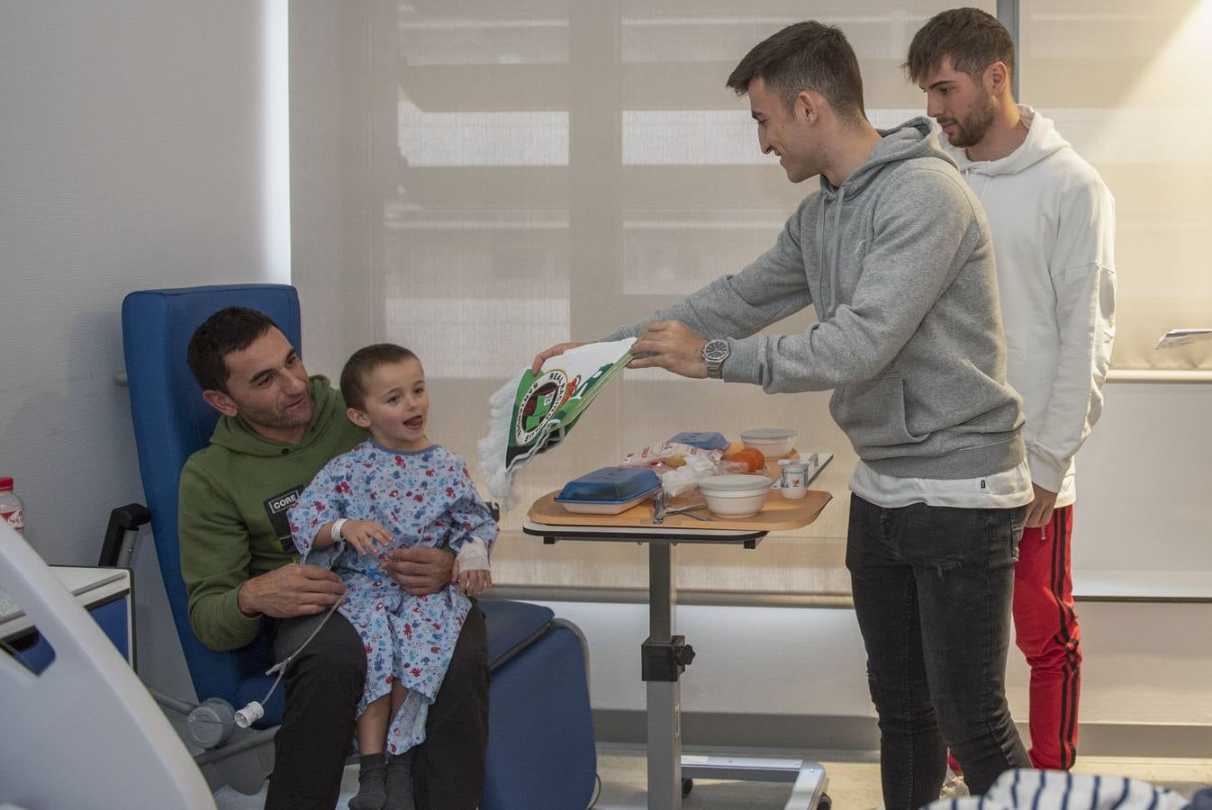 Un niño y su padre observan a Buñuel y Luca, que les regalaron una bufanda.