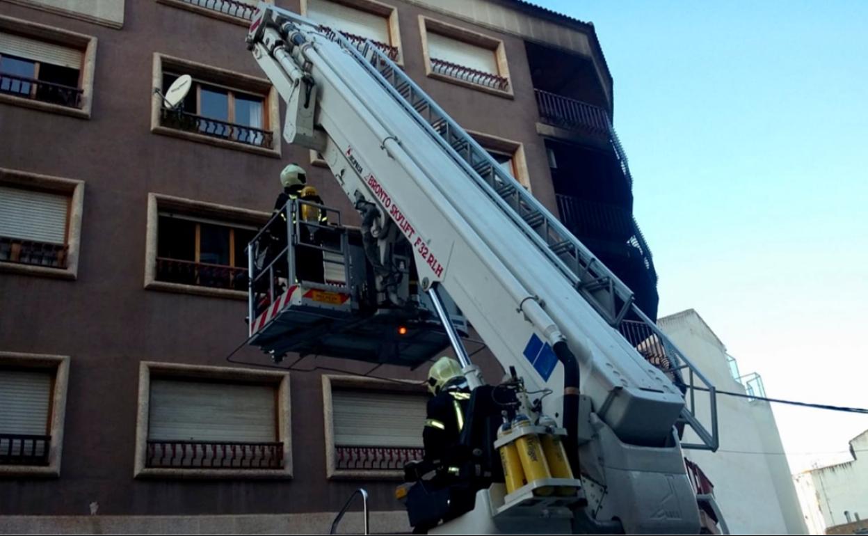 Los bomberos realizan tareas de rescate en la vivienda incendiada.