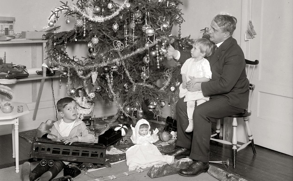 Un padre junto a sus pequeños y los regalos de Reyes.