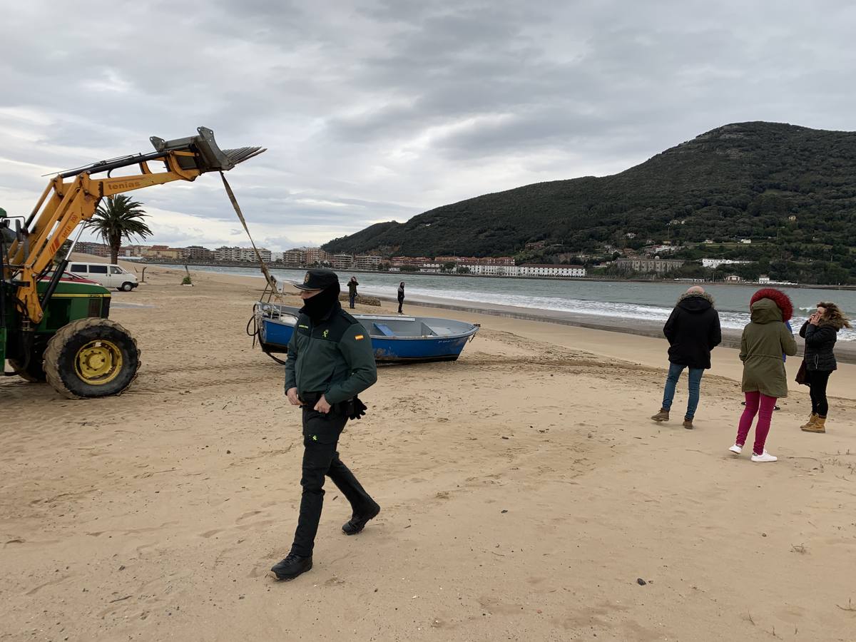 Una excavadora retira la barca de la playa, para llevarla a la explanada del Náutico.