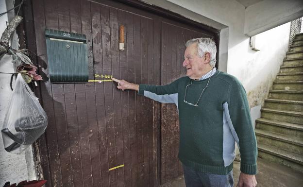 Joaquín Vega, vecino de Villanueva, señala en su garaje hasta dónde llegó el agua en la última inundación.